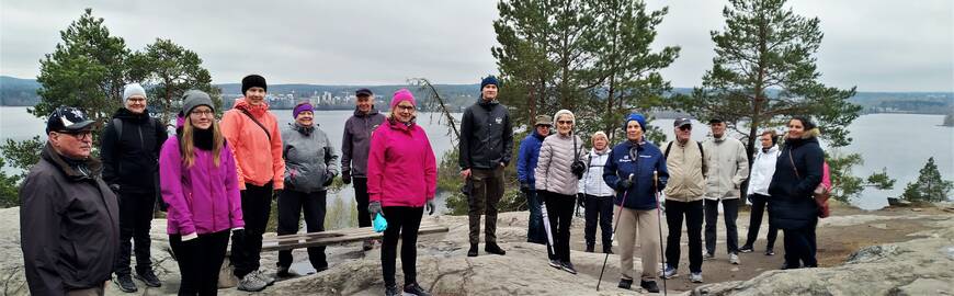 Ulkoiluvaatteissa ihmisiä kalliolla